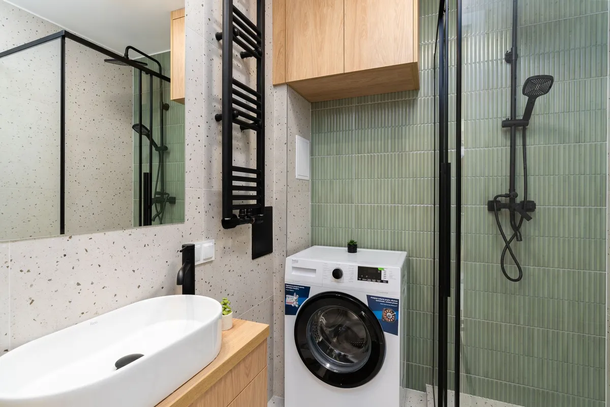 Small bathroom with large-format white tile and frameless glass shower