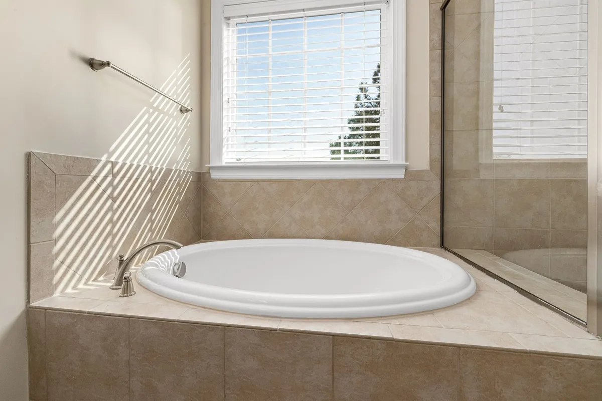 Spa bathroom with soaking tub and natural wood and stone accents
