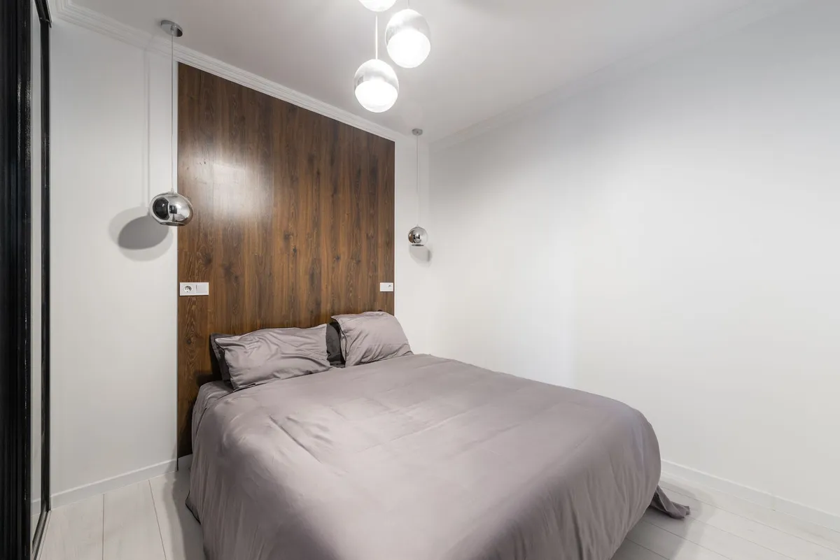 Small bedroom interior design showing space-maximizing furniture layout with platform bed and built-in storage