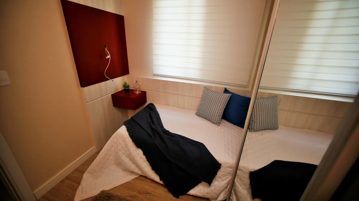 Small bedroom with vertical storage solutions, floating shelves and smart space-saving furniture arrangement