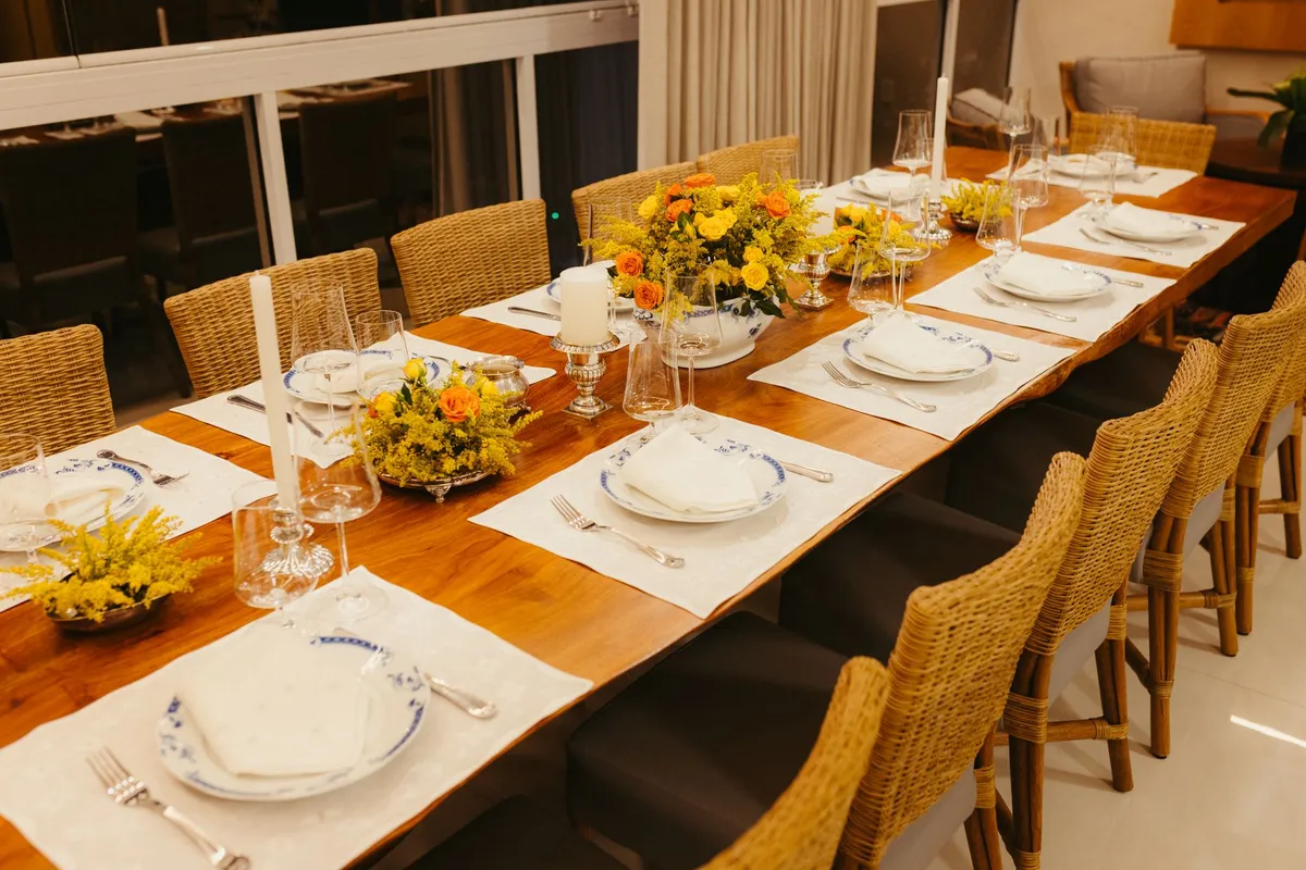 Dining table set for entertaining with candles and warm overhead pendant lighting