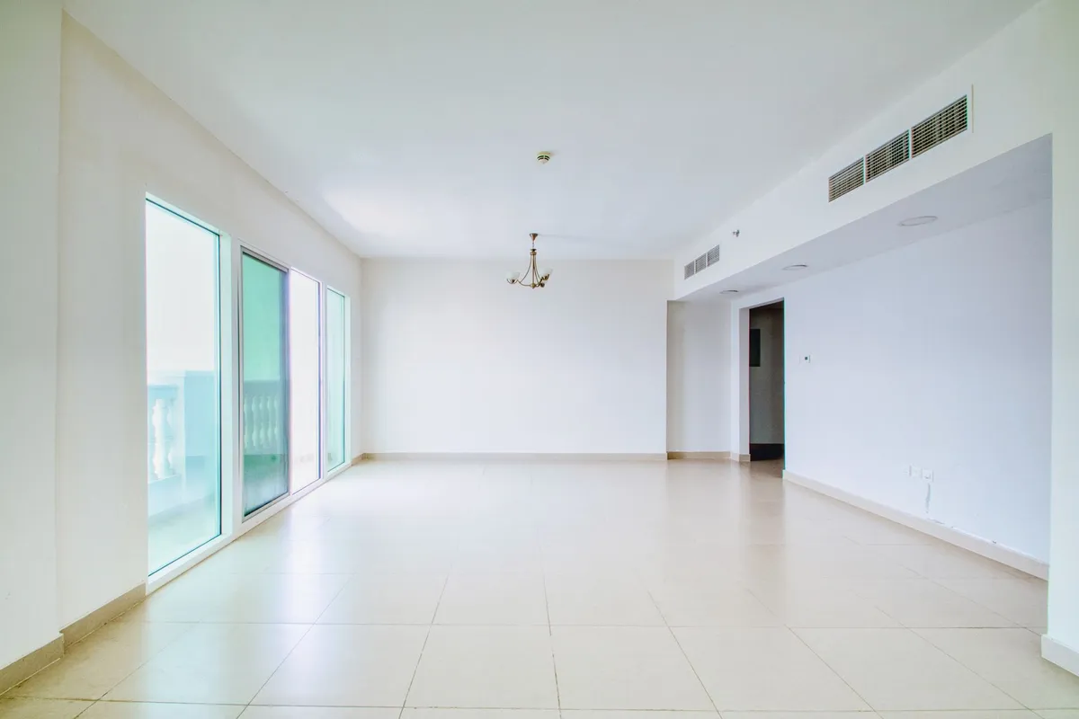 Side-by-side comparison of an empty living room and the same room after AI virtual staging with a sofa, rug, and art