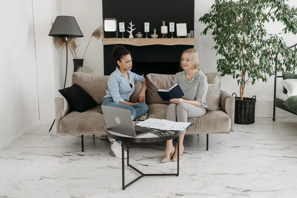 Homeowner using laptop to view AI room design renders and compare interior design options at home