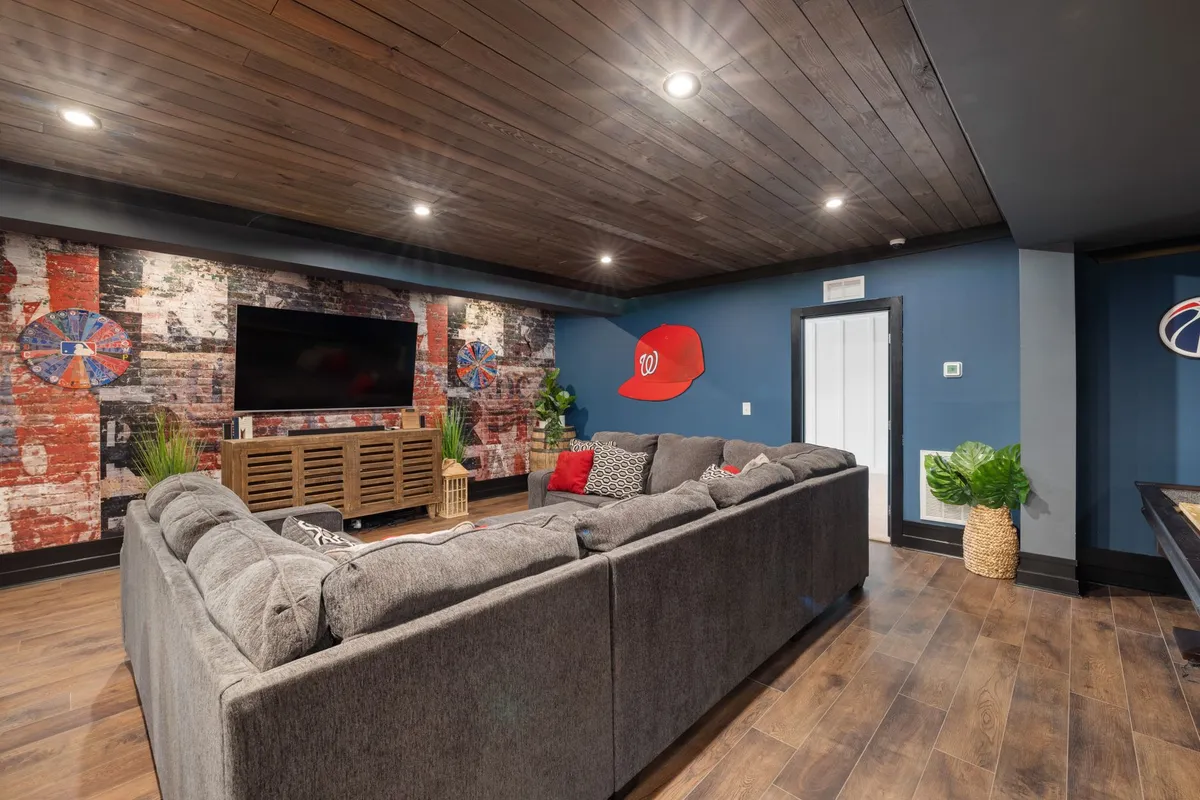 Finished basement home theater with tiered seating acoustic panels and large projection screen