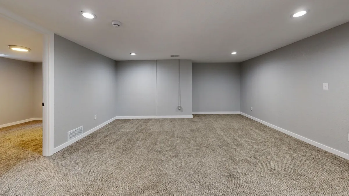 Finished basement home gym with rubber flooring, mirrors and organized equipment