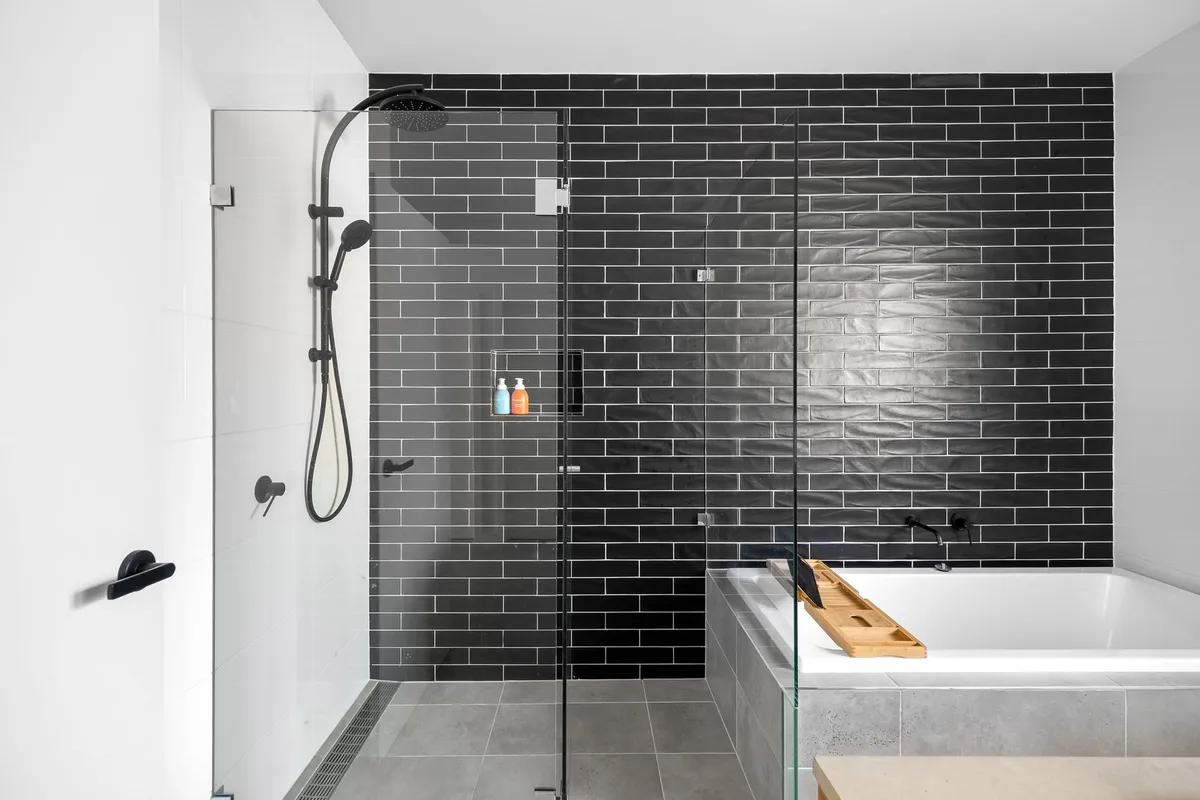 Affordable bathroom makeover showing new white subway tiles shower surround modern faucet and updated lighting