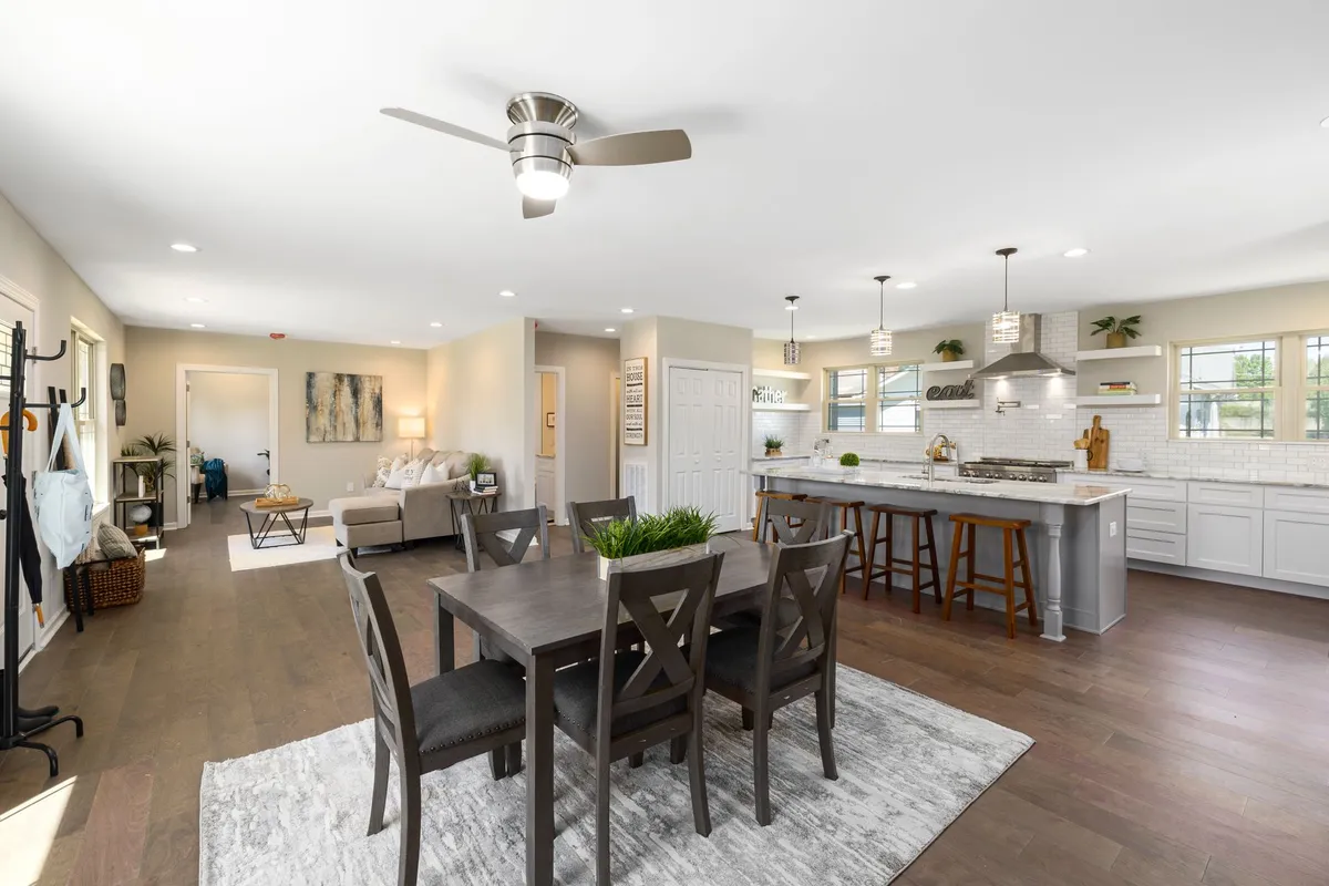 Family dining room with mixed seating arrangement combining chairs and bench, warm pendant lighting above solid wood table