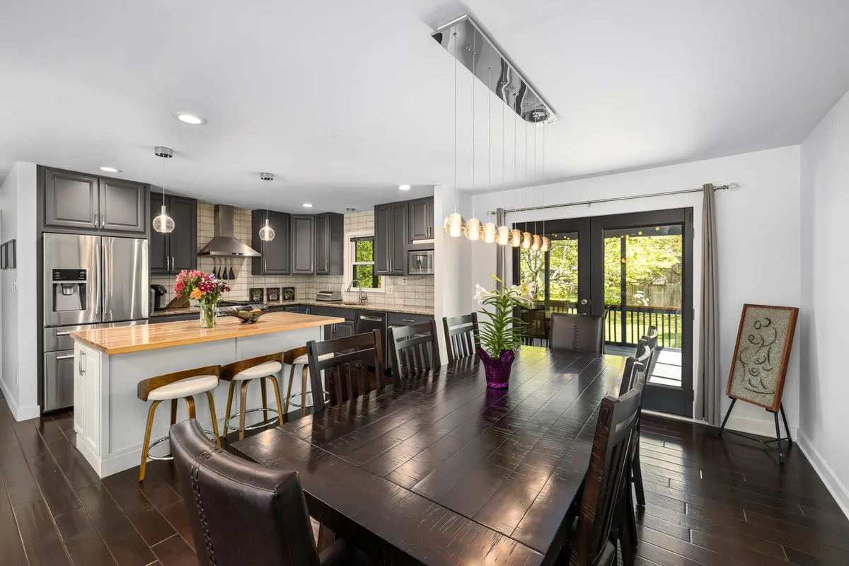 Contemporary dining room with statement pendant lighting, built-in storage credenza, and multi-functional family-scale layout