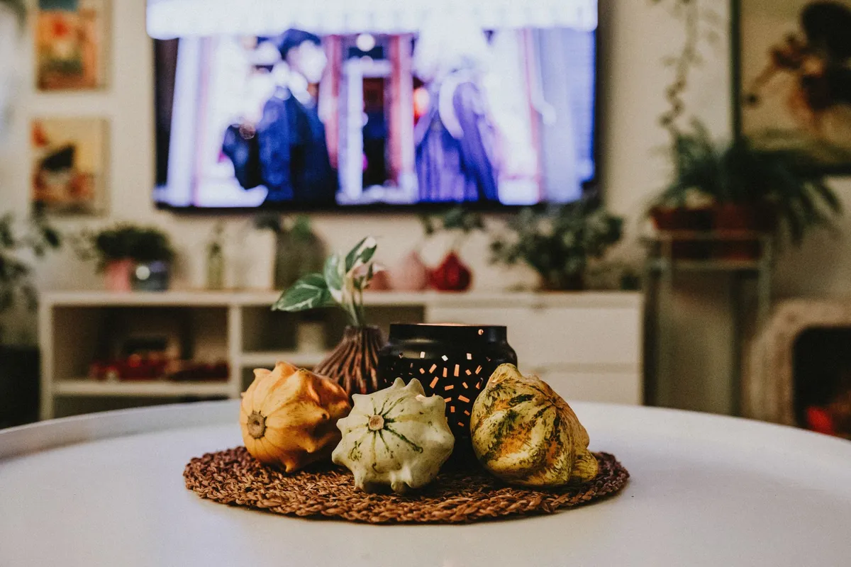 Warm autumn interior with amber lighting, candles and cozy layered furniture