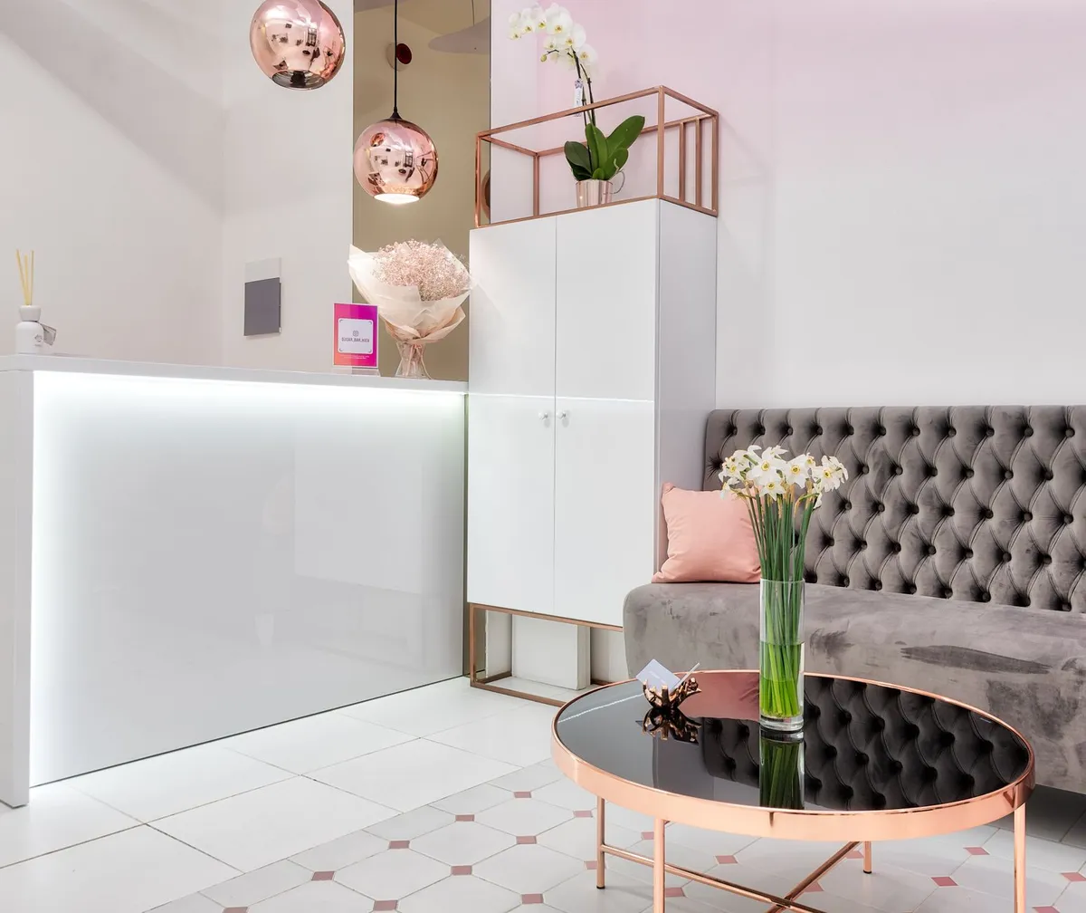 Glam bedroom with tufted velvet headboard, gold light fixtures, and mirrored side tables