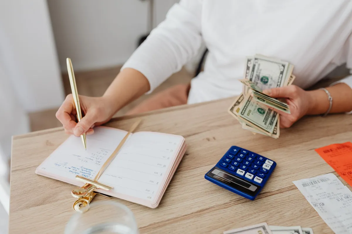 Homeowner reviewing renovation budget spreadsheet and material samples at kitchen table