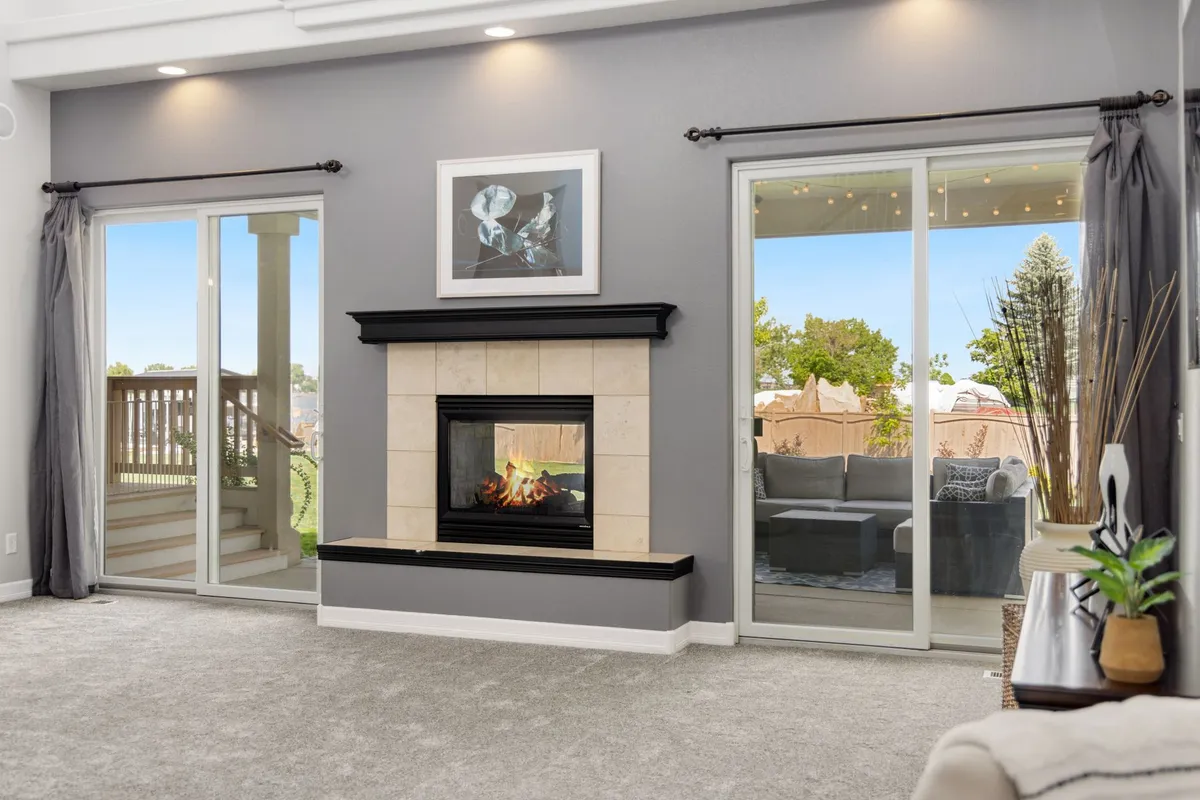 Indoor outdoor living room with large sliding glass doors opening to patio