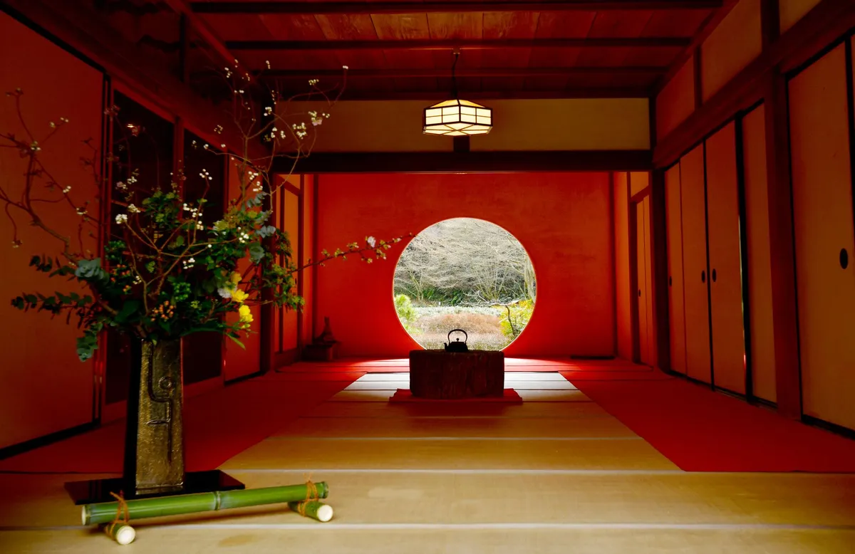 Japanese zen interior with low platform bed, natural wood tones, shoji screens and minimalist negative space