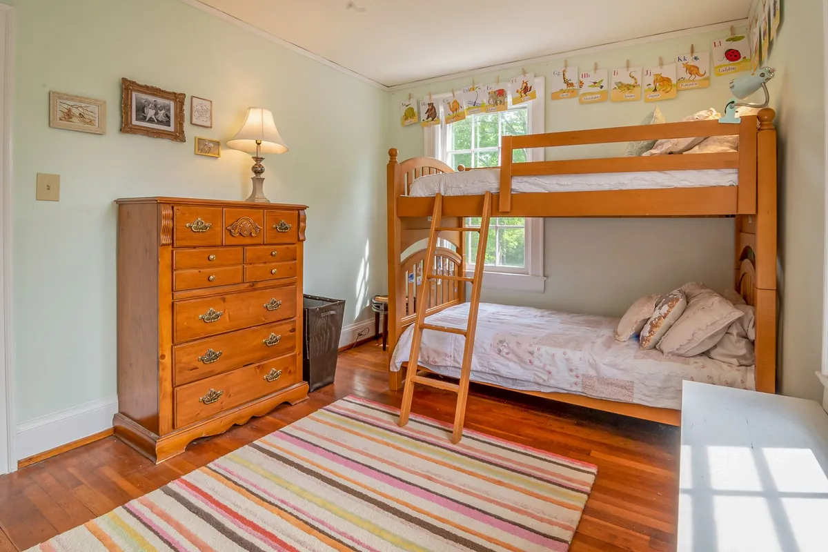 Bright kids room with neutral sage green walls convertible furniture and organized toy storage