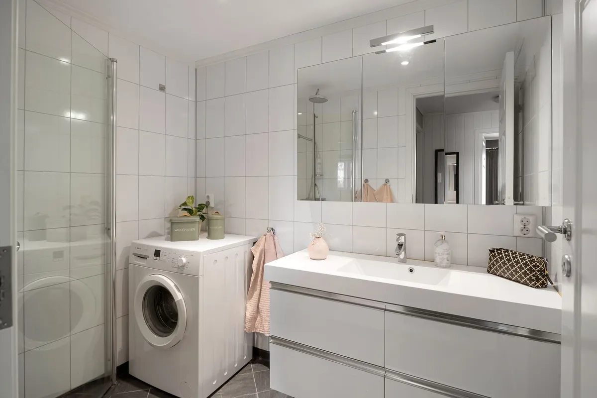 Well-designed laundry room with front-load washer and dryer on pedestals and folding counter above