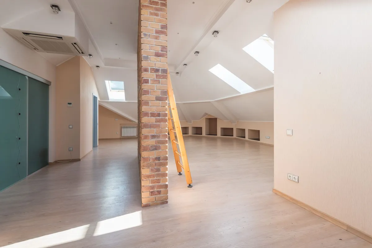 Loft conversion living space with modern interior design and large roof windows