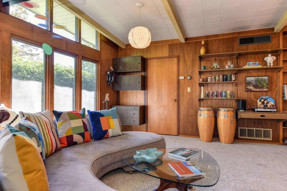 Mid-century contemporary bedroom with low platform bed, walnut nightstands, and warm terracotta wall