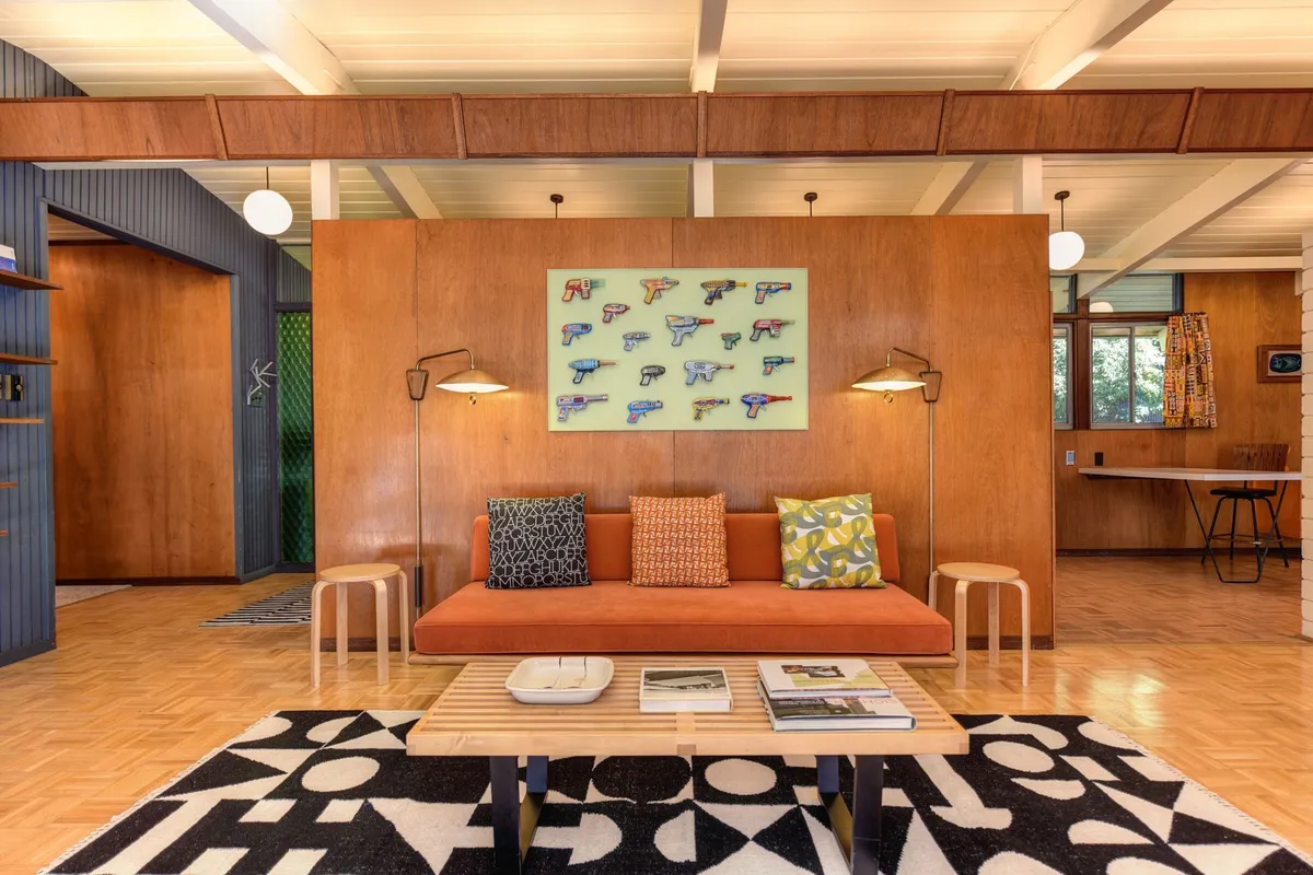 Mid-century modern living room with walnut furniture tapered legs Eames chair and warm wood tones