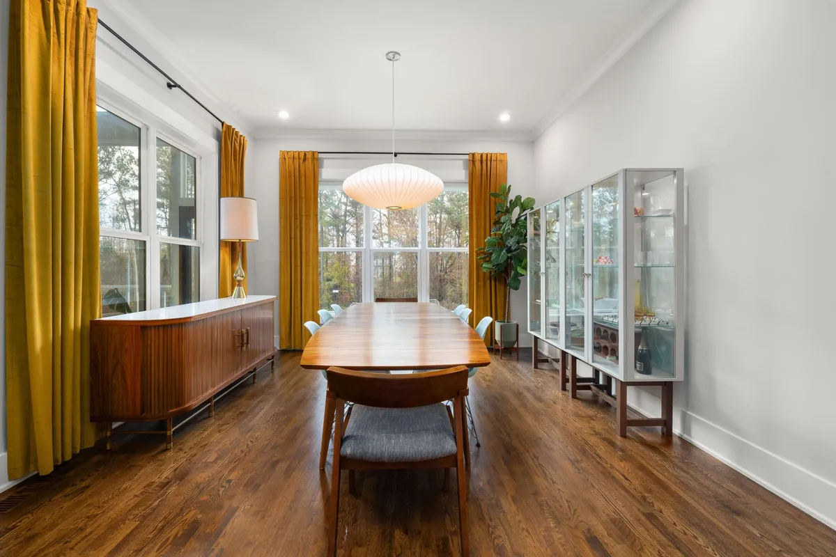 Mid-century modern bedroom with low platform bed walnut dresser olive green accent wall and arc lamp
