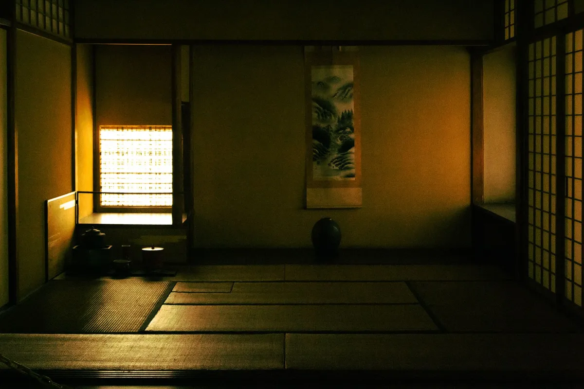Zen-inspired room with tatami mat, shoji window treatment, and single ikebana arrangement