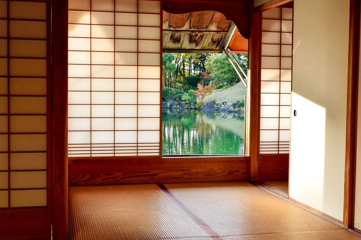 Japanese-inspired bedroom with low platform bed, natural wood, and serene neutral tones
