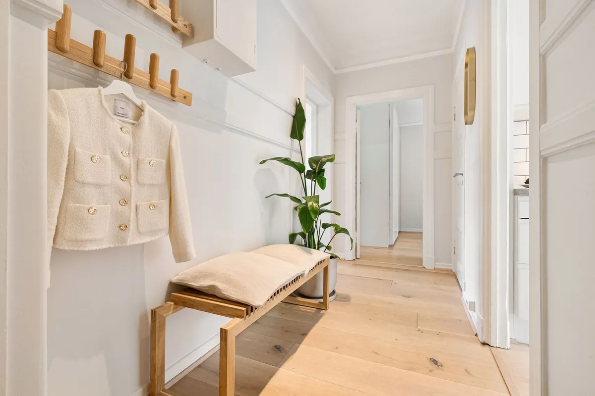 Small but organized mudroom entry with hooks, baskets, and shoe storage