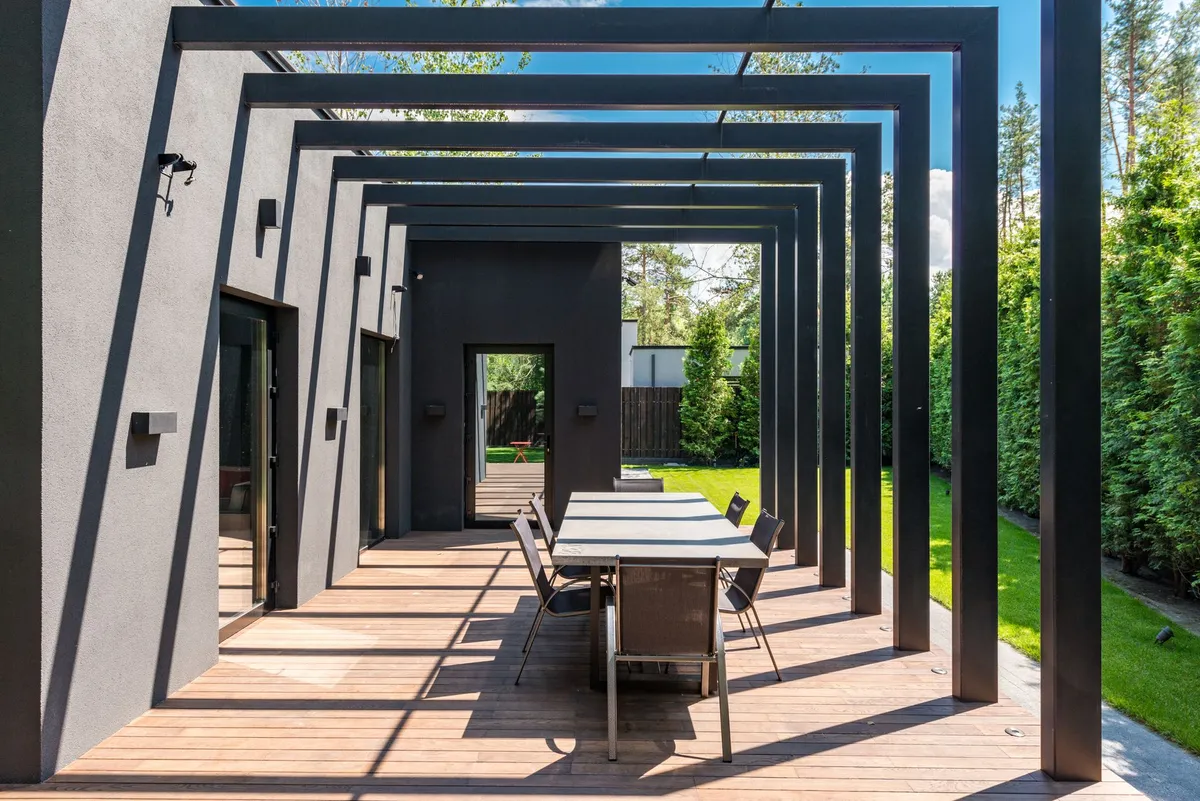 Outdoor living space with pergola, comfortable seating area, and integrated fire feature