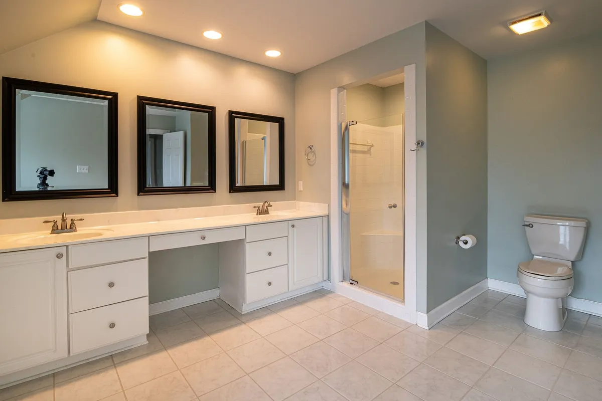 Renovated modern kitchen with new white cabinetry, stone countertops, and updated fixtures