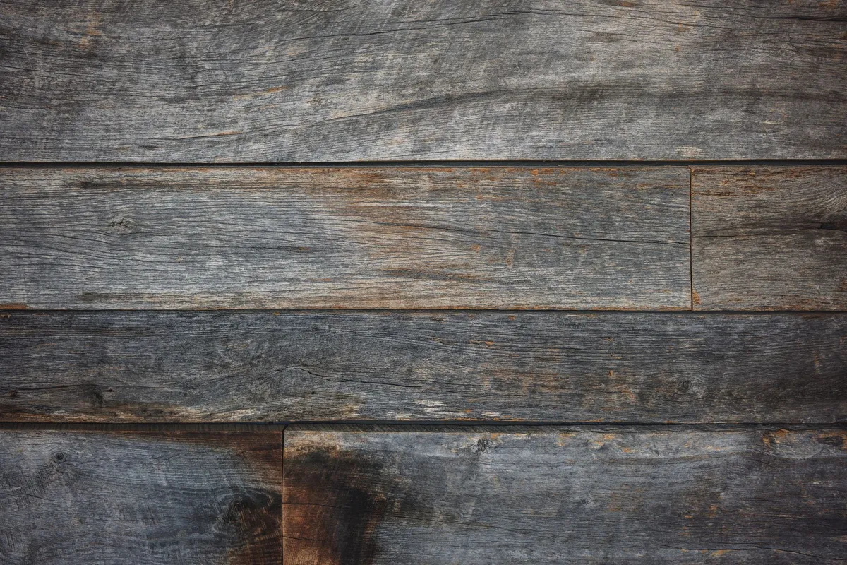 Rustic bedroom with reclaimed wood headboard, warm textiles, and stone accent wall bringing natural elements indoors
