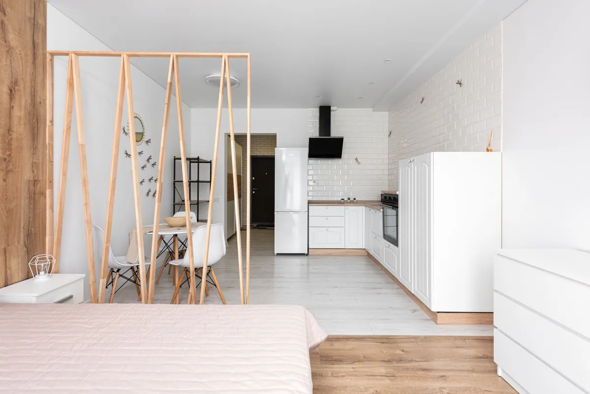 Murphy wall bed folded up to reveal a multi-functional living area with storage ottoman and slim console table