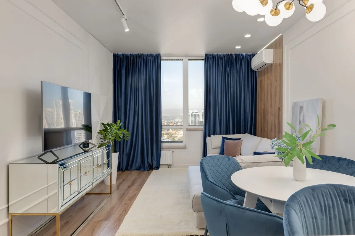 Small living room with nested side tables, daybed sofa, and wall-mounted shelving keeping floor plane clear