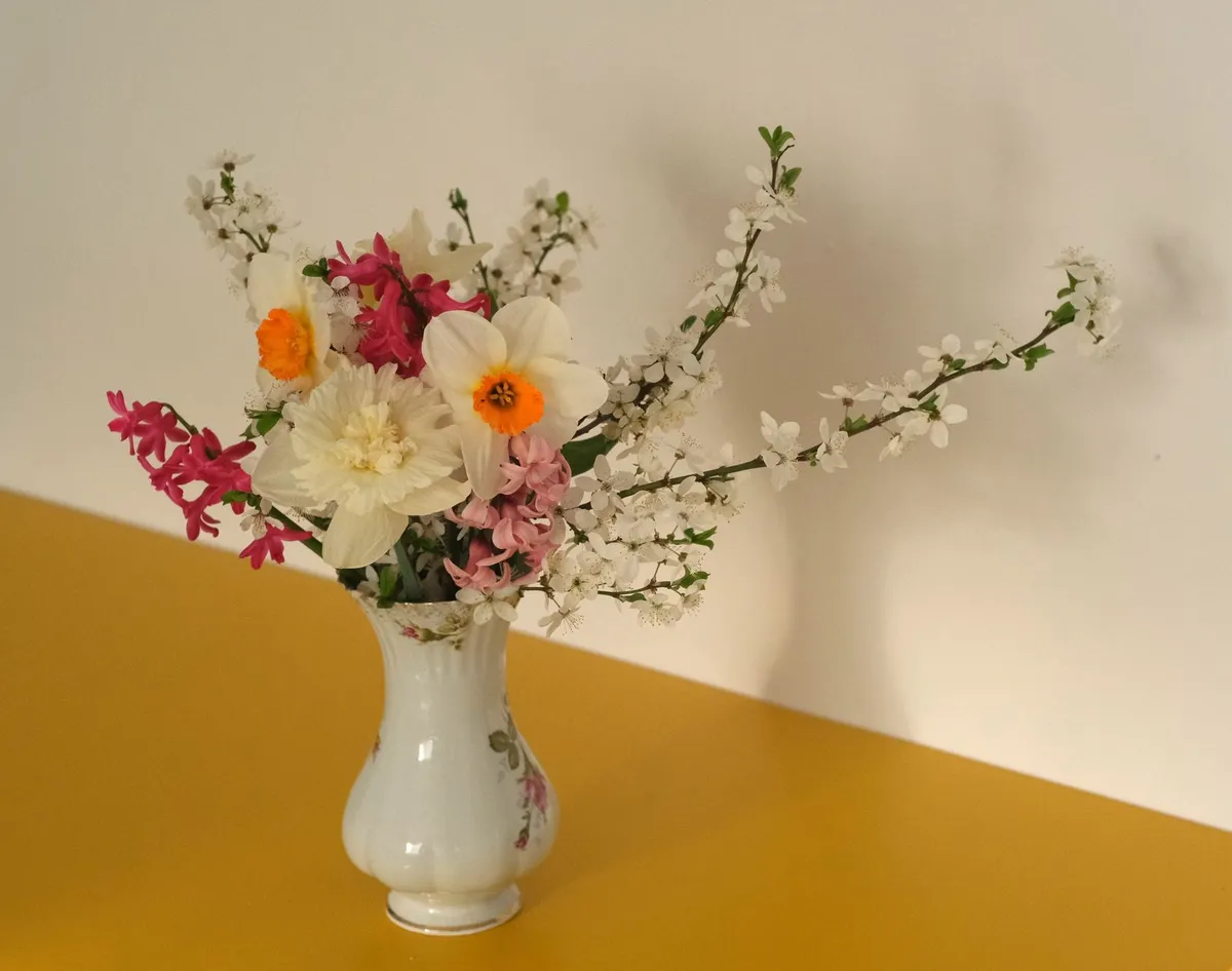 Bright spring living room with fresh flowers and light airy color palette