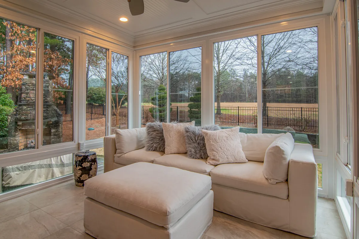 Sunroom renovation with plant integration, comfortable lounge chairs, and morning light