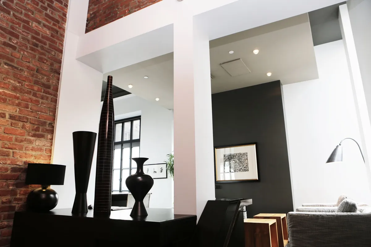 Urban loft interior with exposed brick wall, concrete floors, and steel windows