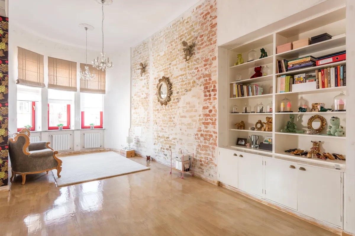 Open-plan urban loft living area with zone definition using large rug and industrial pendant lights