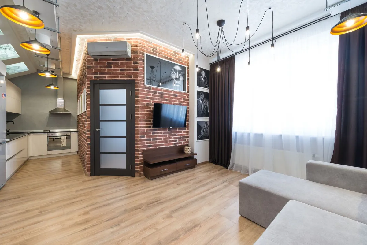 Industrial-style apartment with dark steel shelving, exposed beam detail, and leather furniture