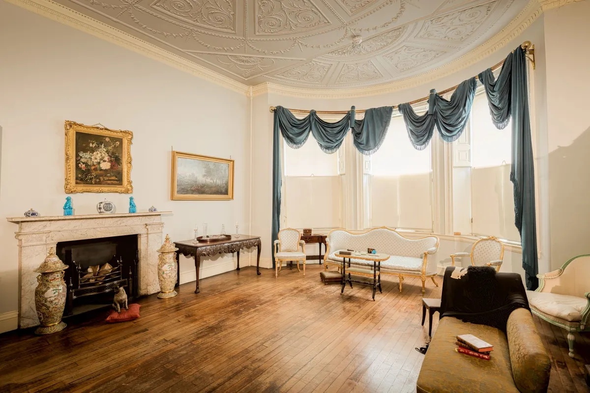 Victorian-style room with ornate wallpaper and rich jewel tones