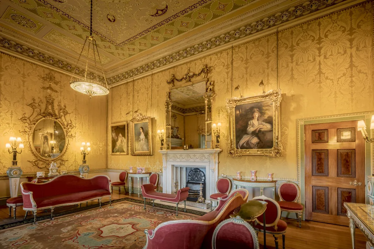 Ornate Victorian-style interior with layered textiles and dark furniture