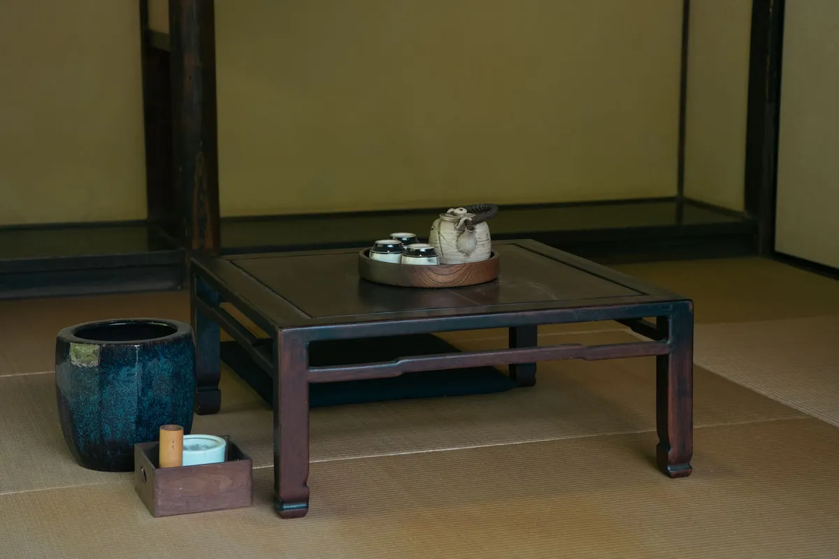 Wabi-sabi living room with linen upholstery, handmade pottery, aged wood details, and soft neutral palette
