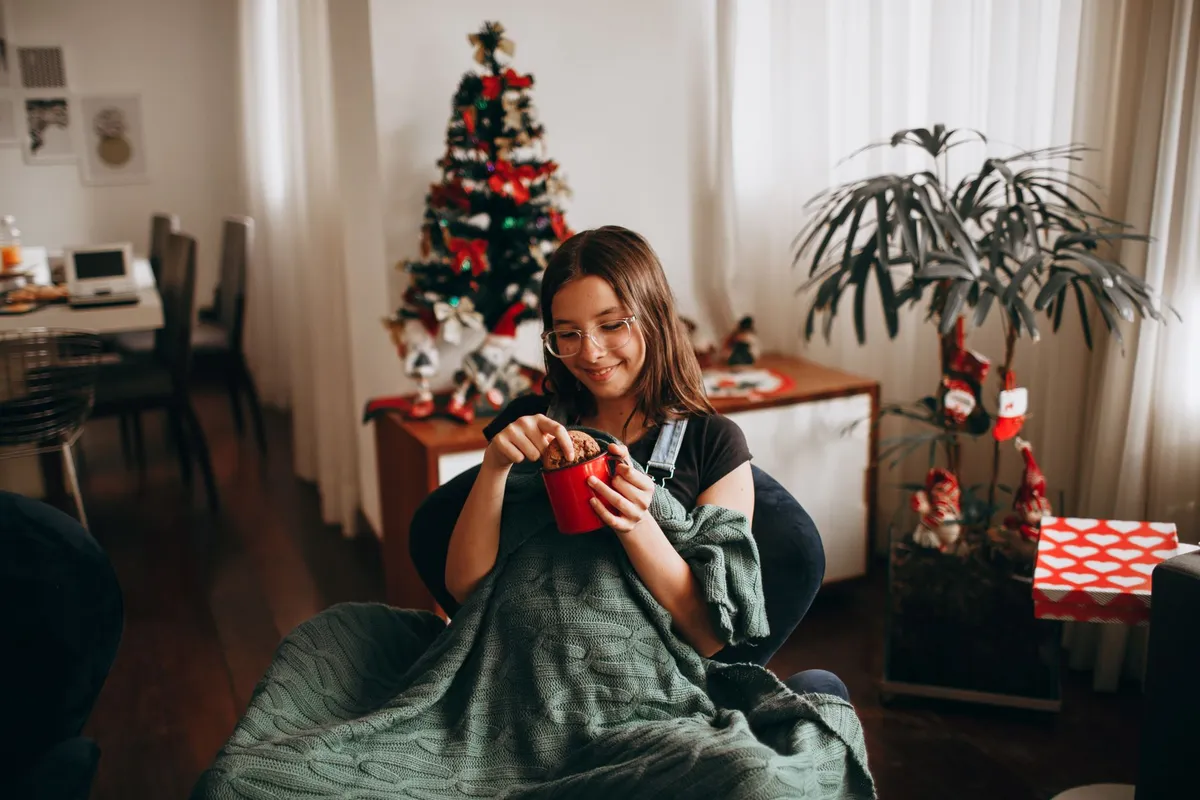 Hygge-style winter home interior with blankets, candles and warm wood tones